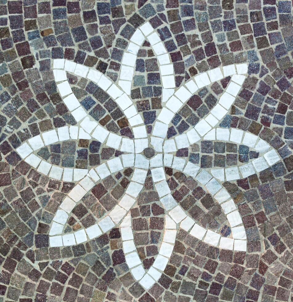 A mosaic tile with a flower design on it photo