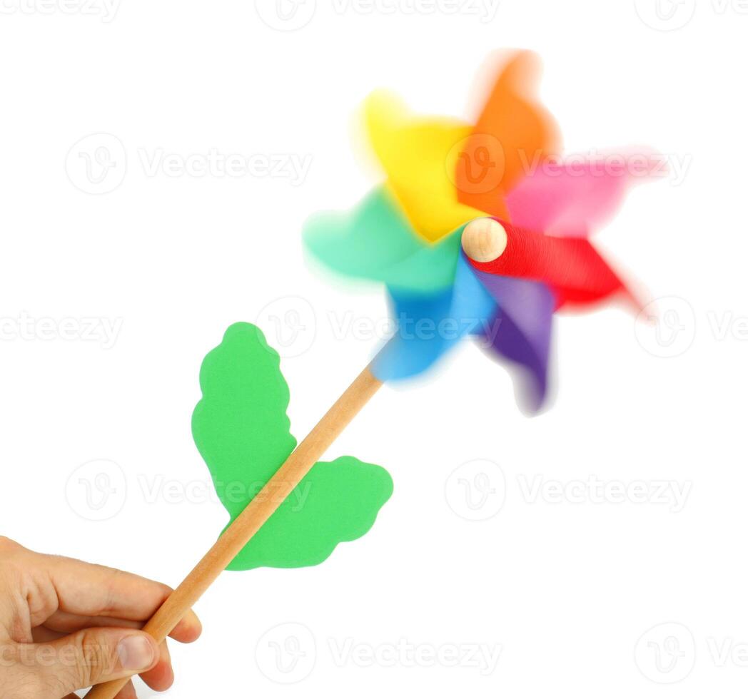 A hand holding a pinwheel with colorful leaves photo