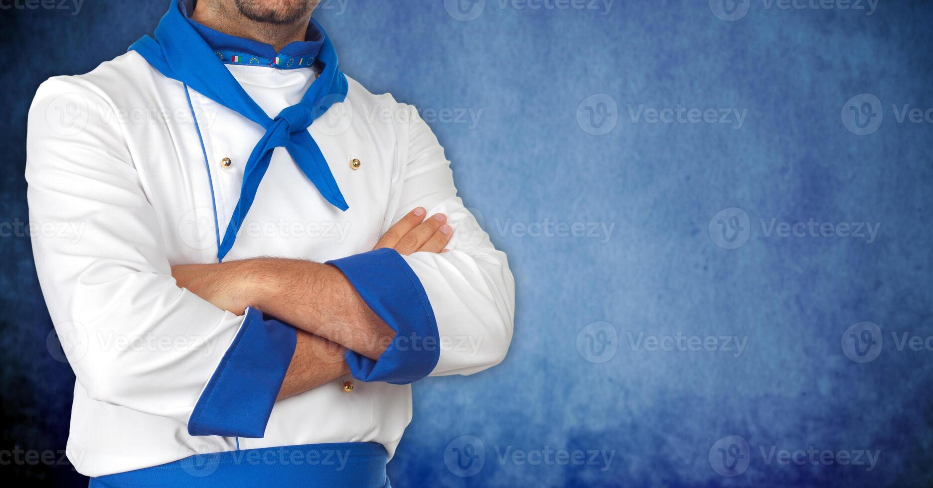 A man in a chef's uniform with his arms crossed photo