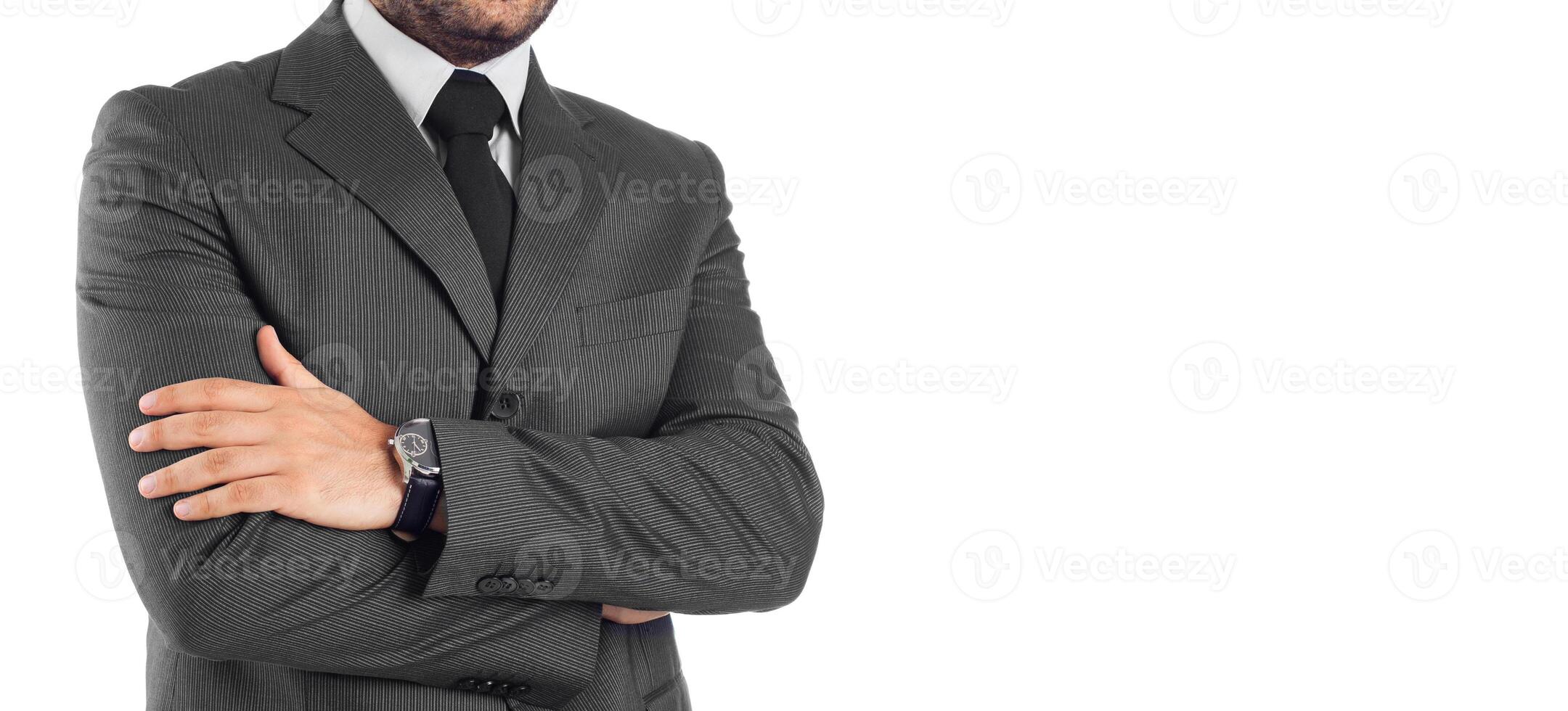 A man in a suit and tie standing with his arms crossed photo