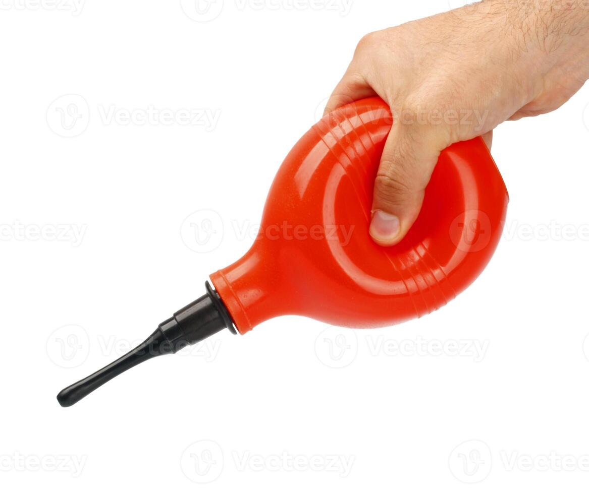 A person holding a red plastic tube with a black handle photo