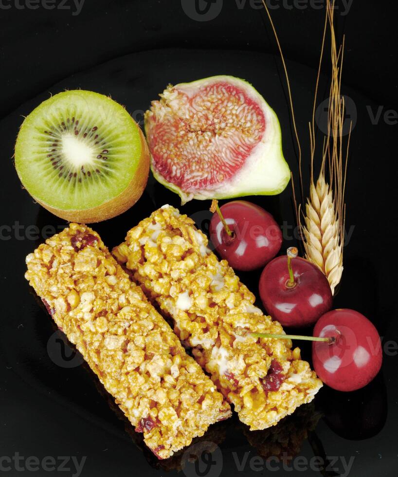 A plate with a bunch of fruit and cereal bars photo