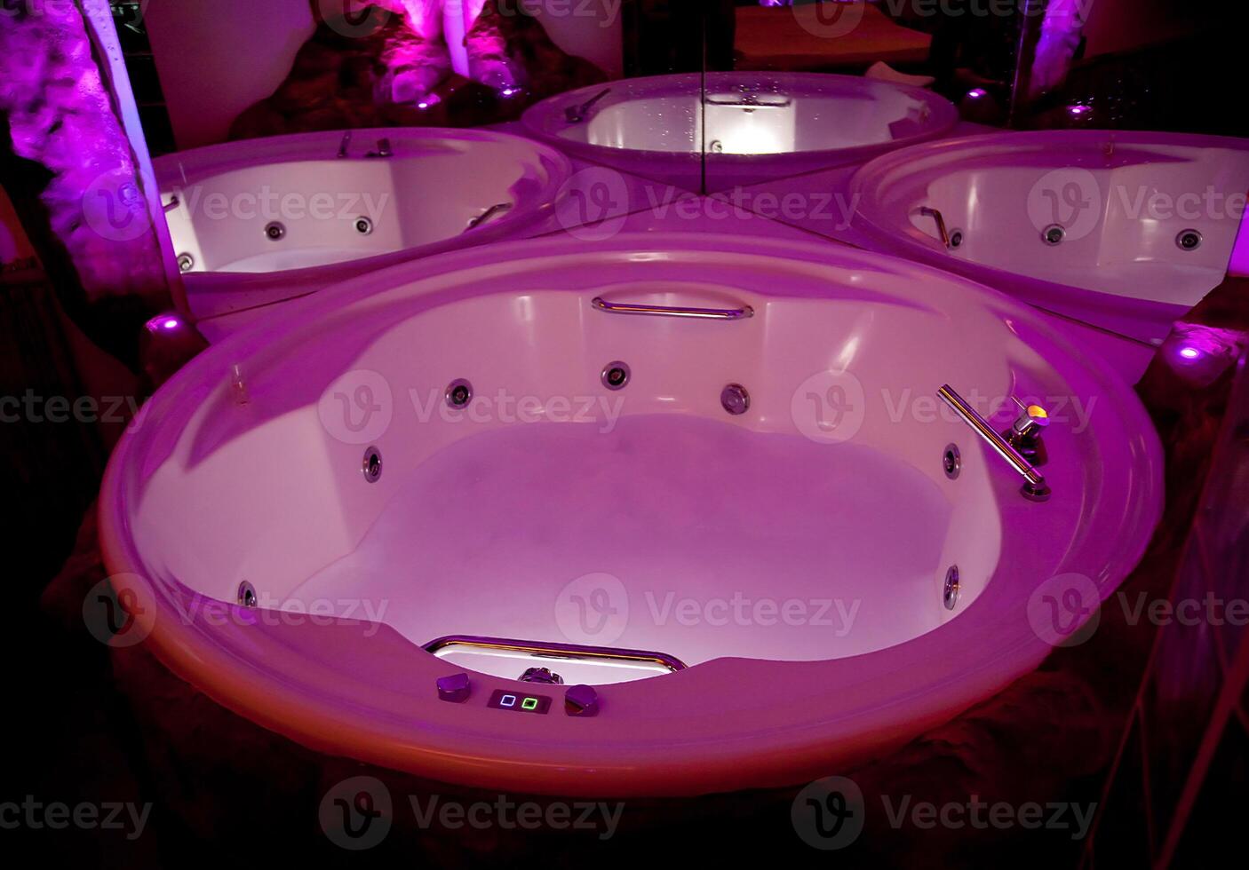 A large jacuzzi tub with purple lights photo