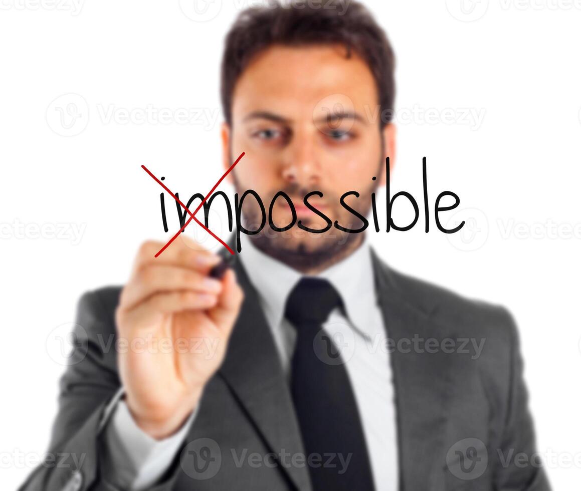 Impossible - business man writing word impossible on transparent screen photo