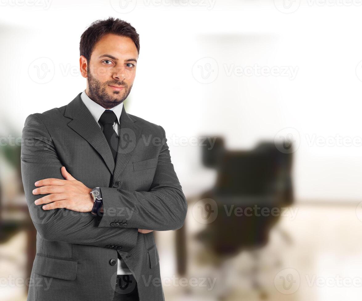 A man in a suit and tie standing in an office photo
