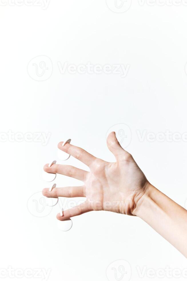 White nail clippers held by a hand with outstretched fingers on a white background. photo