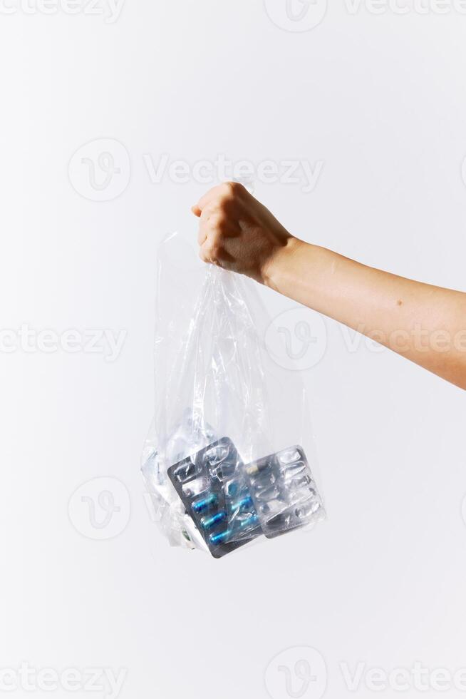 Man holding a bag filled with plastic bottles on a white background with space for text photo