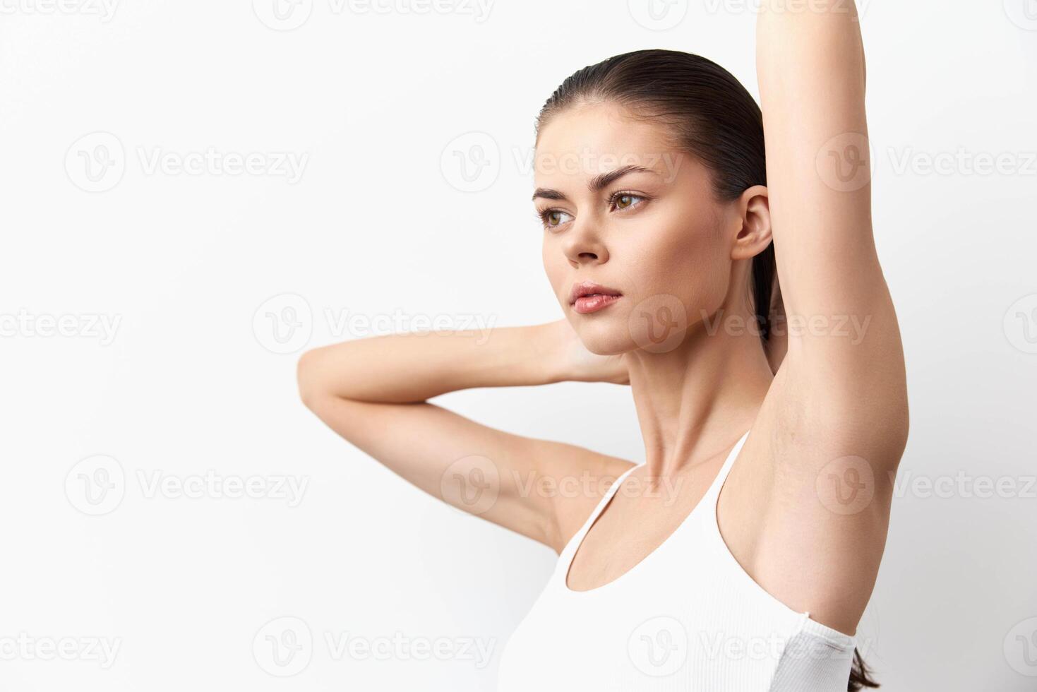 Woman with sleek hair poses elegantly in a minimalistic studio environment Her body language conveys photo