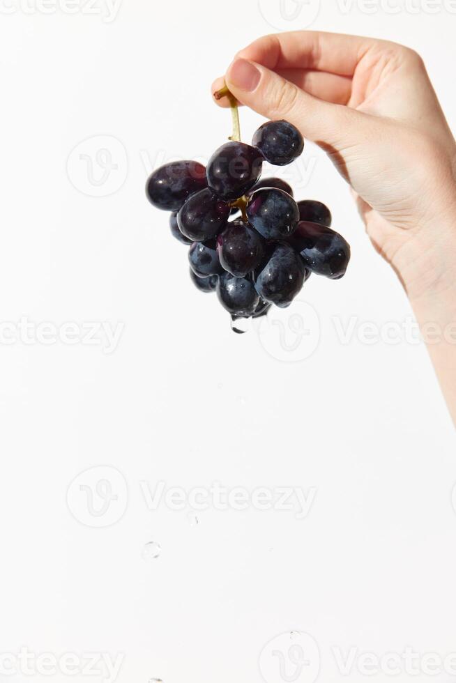 Person holding grapes over white surface with water drop in middle. fresh and vibrant image suitable photo
