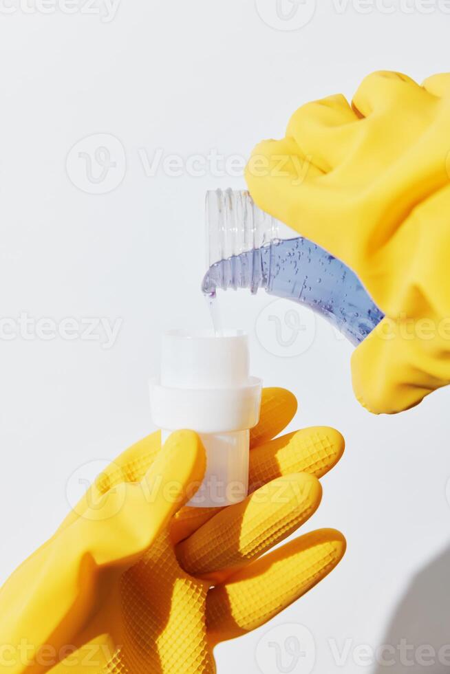 Hands in yellow gloves holding bottles of hand sanitizer. personal hygiene concept. protection photo