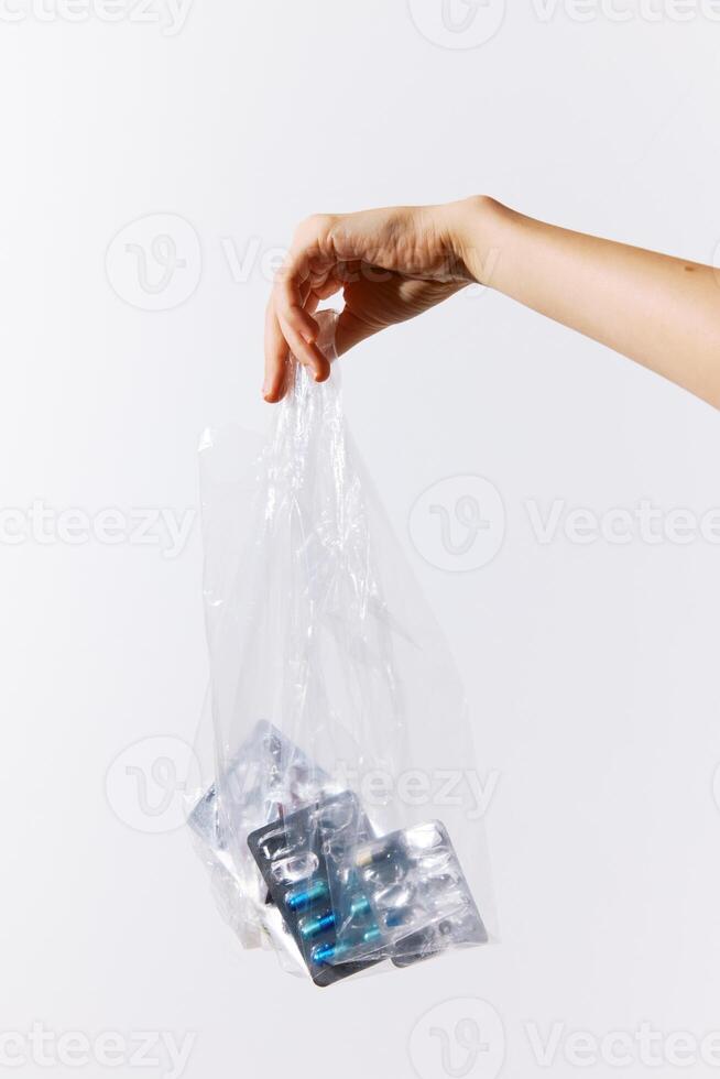Bag full of pills held by a person on a white background with copy space. medical concept image. photo