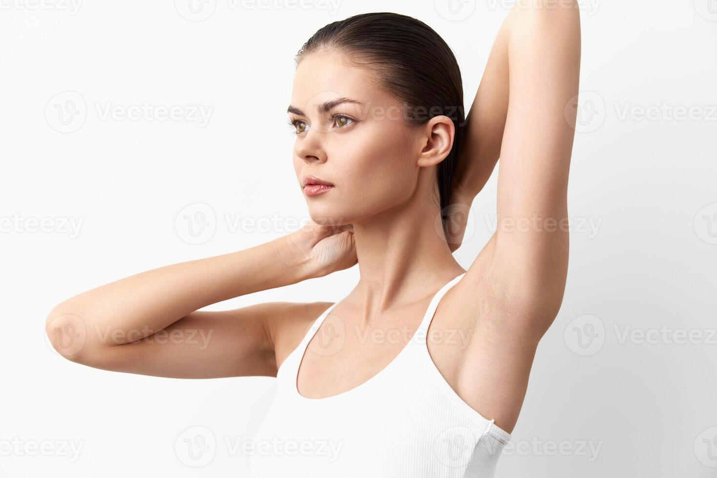 A striking image of a young woman in a sleeveless top, posing with her arms raised, highlighting photo