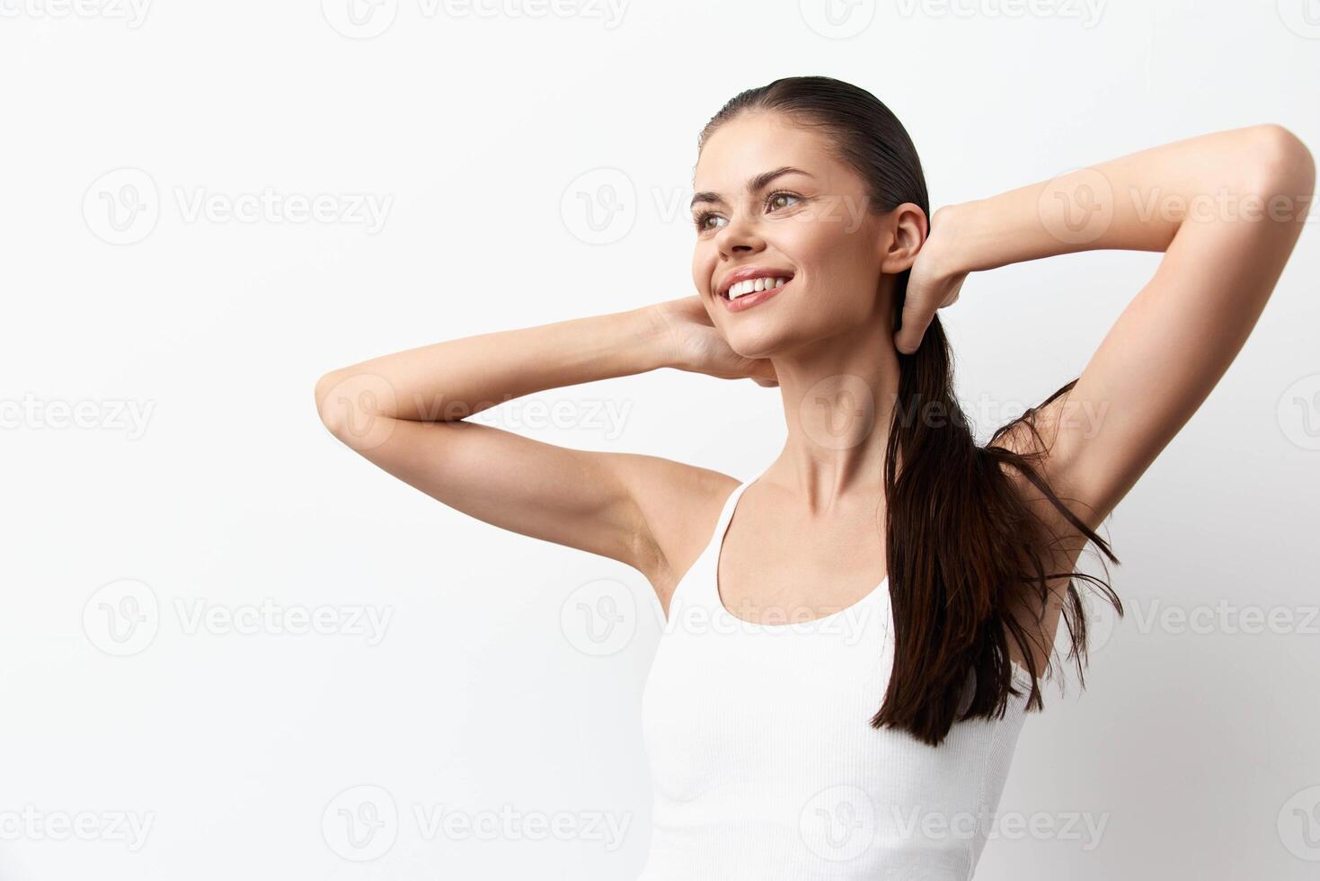 a young woman with long hair smiling brightly while running her hands through her hair, showcasing photo