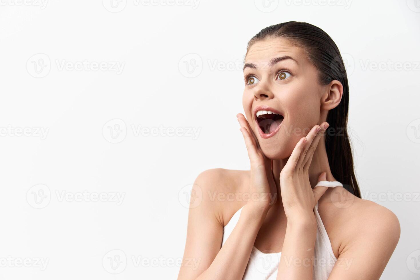 Happy young woman displaying excitement and surprise with a joyful expression She has long, wet hair photo