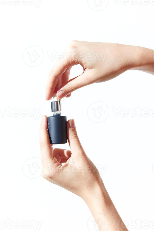 Person holding two perfume bottles, one empty and one full, against a white background. photo
