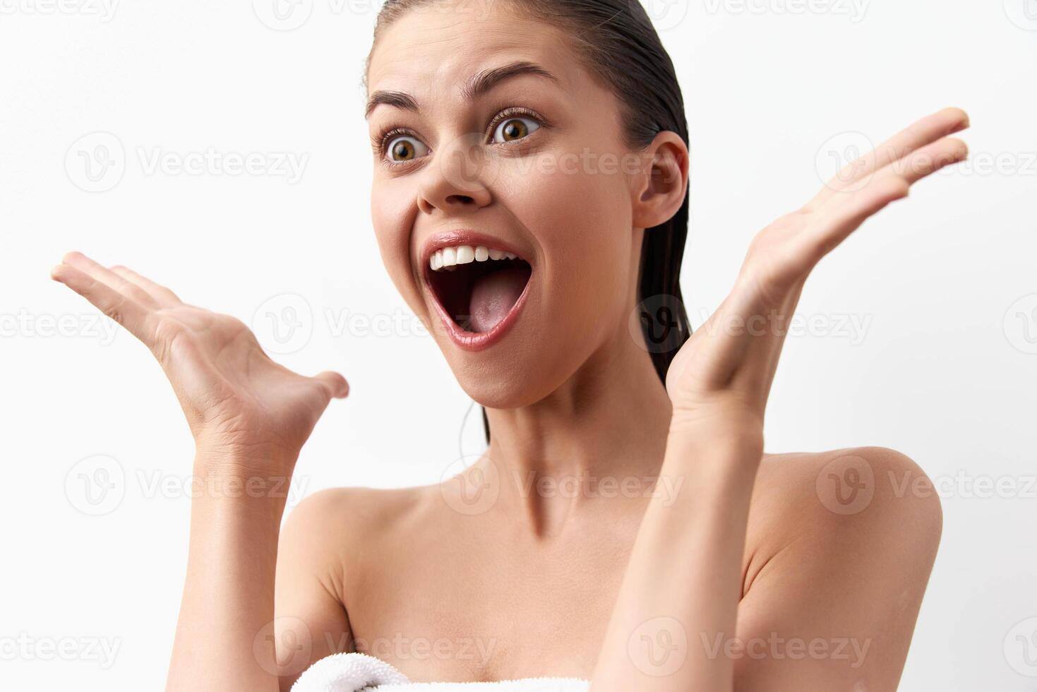 Happy young woman with wet hair, enthusiastically raising her hands, displaying excitement and photo