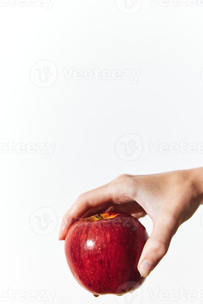Hand holds apple on white background with copy space for message or logo. photo