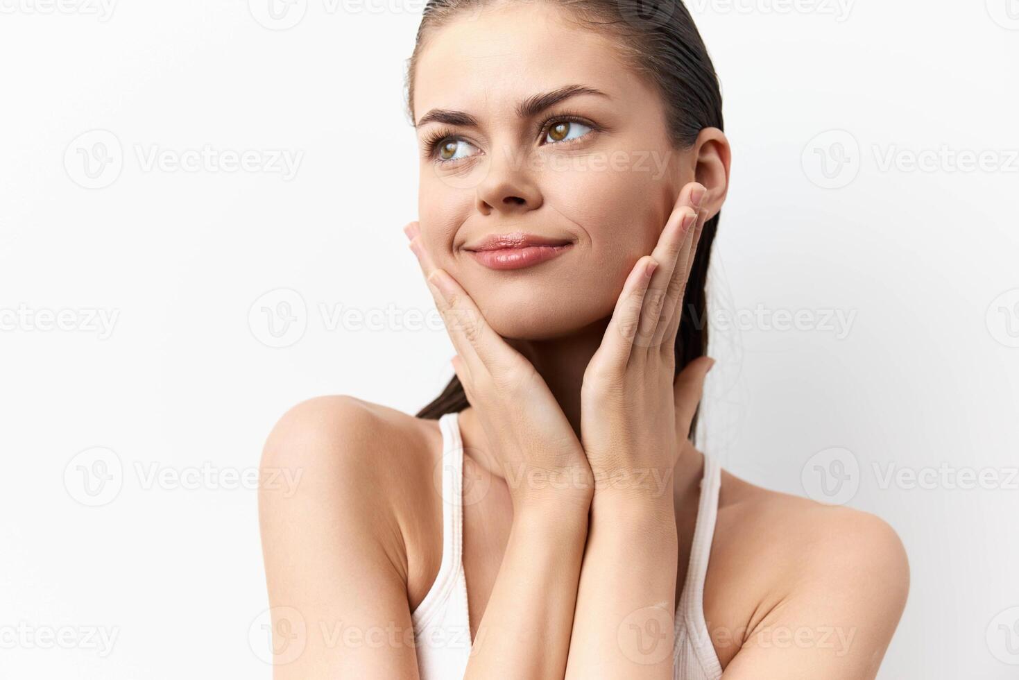 Close up of a lovely young woman with a serene expression, gently holding her face The image photo