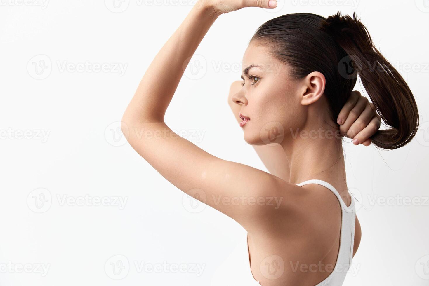 This image captures a young woman with a sleek ponytail in a side profile, exuding poise and photo