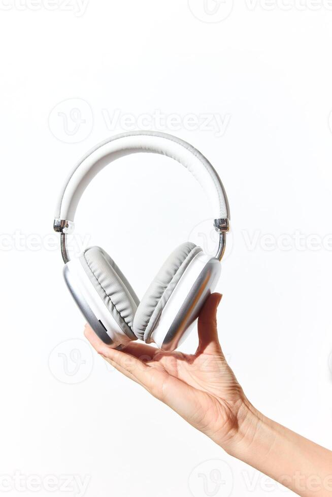 Hand holding headphones on white background with copy space. ideal for adding text or logo. photo