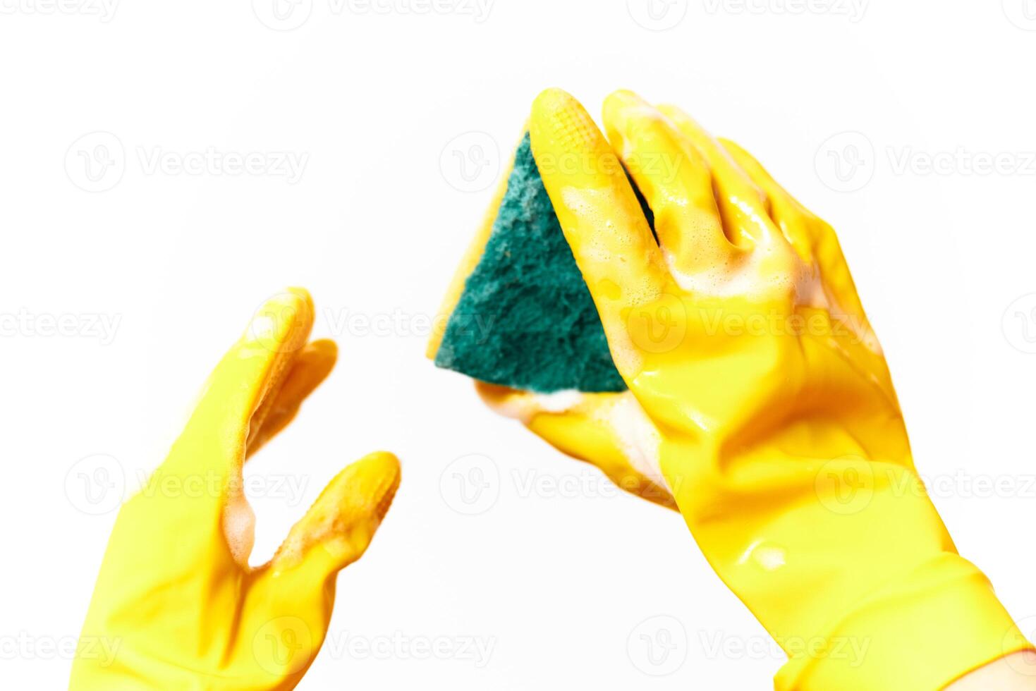 Yellow rubber gloves holding sponge and green sponge on white background. photo