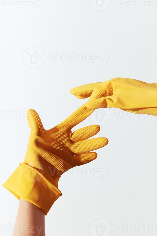 Two yellow rubber gloves hands connecting over white background. a symbol of unity and cooperation. photo