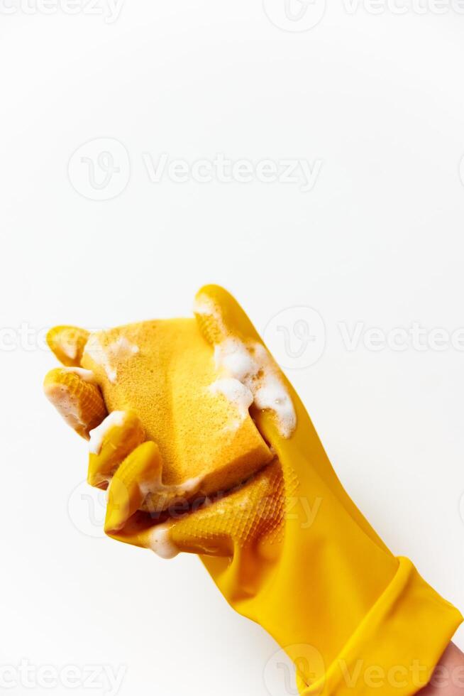Yellow rubber gloves being worn by a person holding a sponge and soap. photo