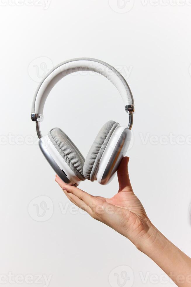 Person holding white headphones on white background with space for text. communication and photo