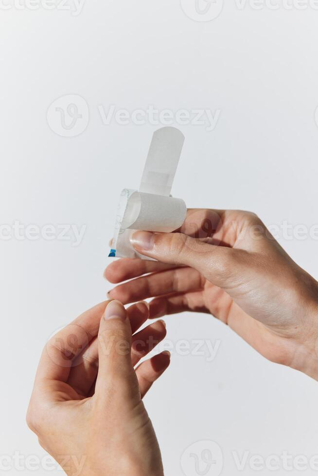 Two individuals with white bandages on their fingers holding small plastic pieces. photo