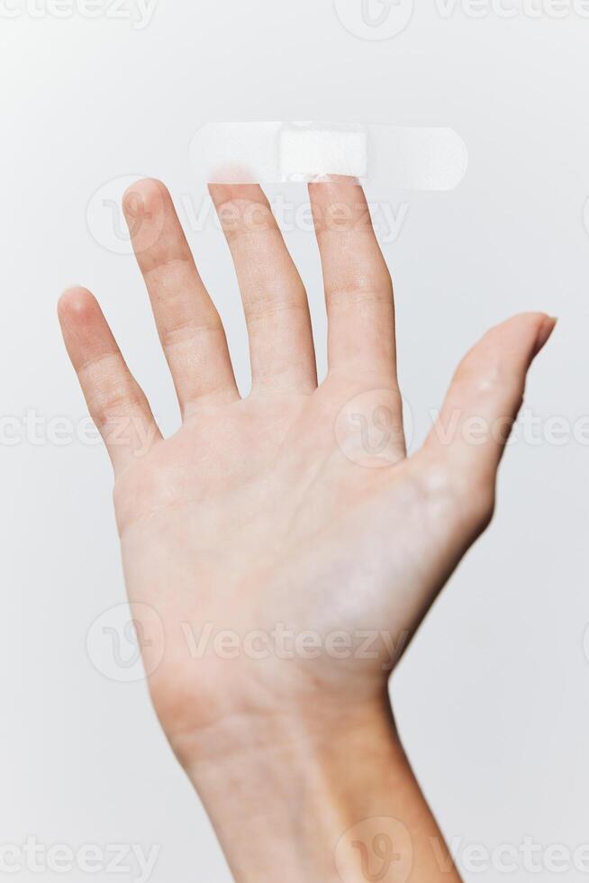 Band-aid in hand on white background, another band-aid visible on hand. concept of first aid and photo