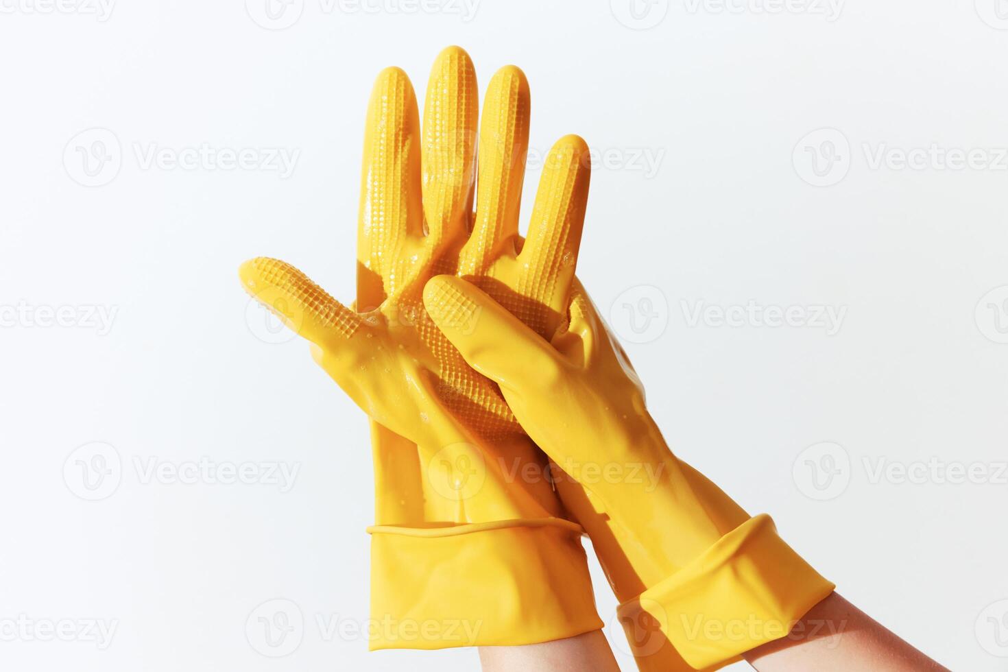 Woman's hand wearing yellow rubber gloves, isolated on white background. photo