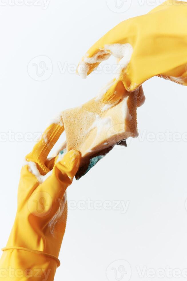 Yellow gloves hands holding soap and sponge on white background. ideal for cleaning and household photo