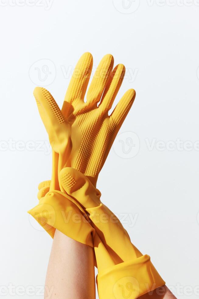 Yellow rubber gloves on hand isolated on white background with copy space. a concept of cleaning or photo
