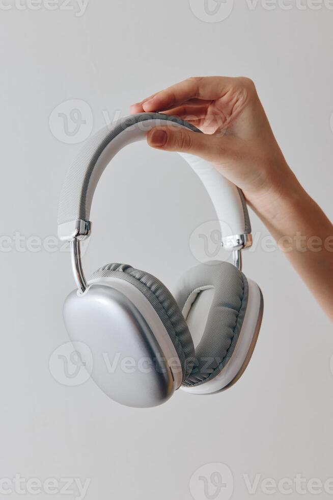 Headphones being held by a hand on a white background, with space available for text or image photo