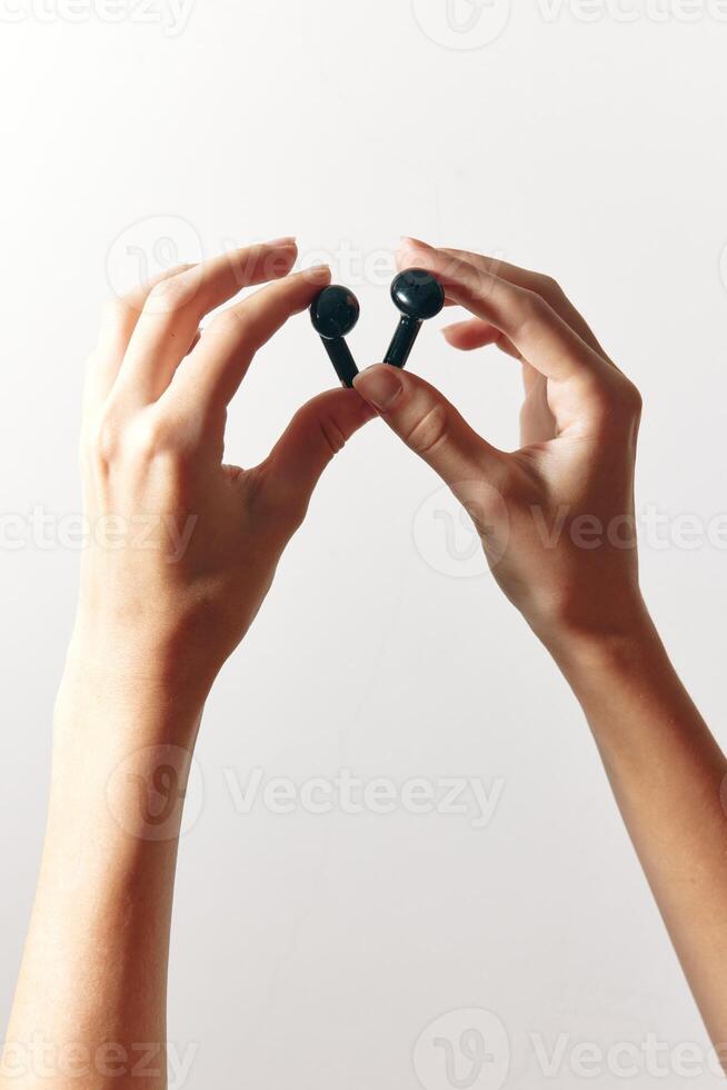 Earbuds being held by hands on a white background. wireless headphones with no visible logo. photo