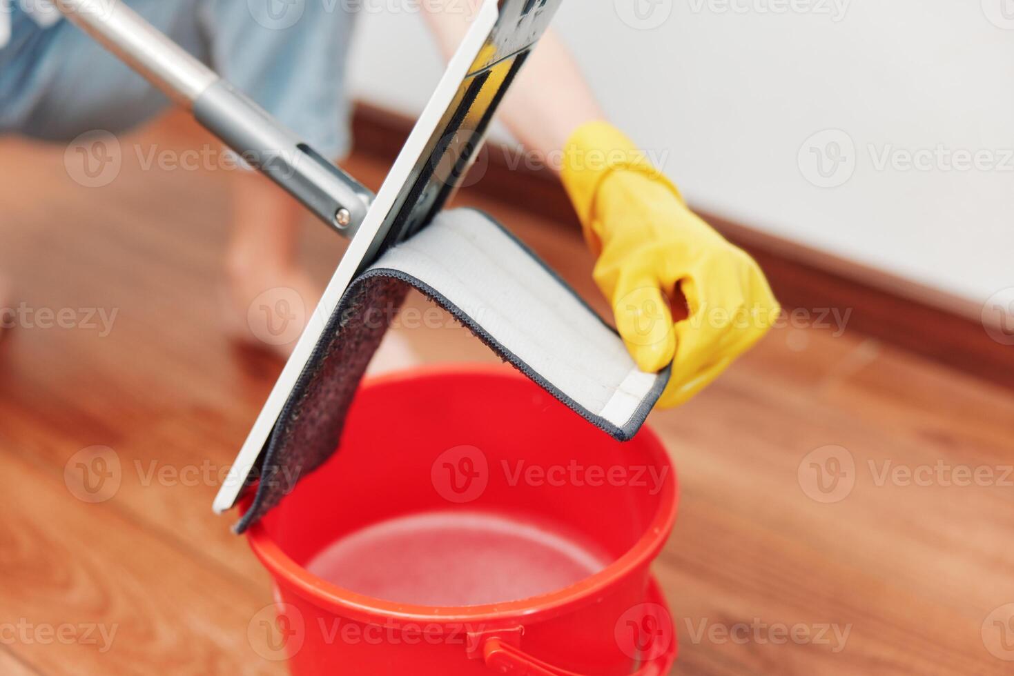 Woman cleaning floor with mop and bucket of water. household chores concept. professional cleaning photo