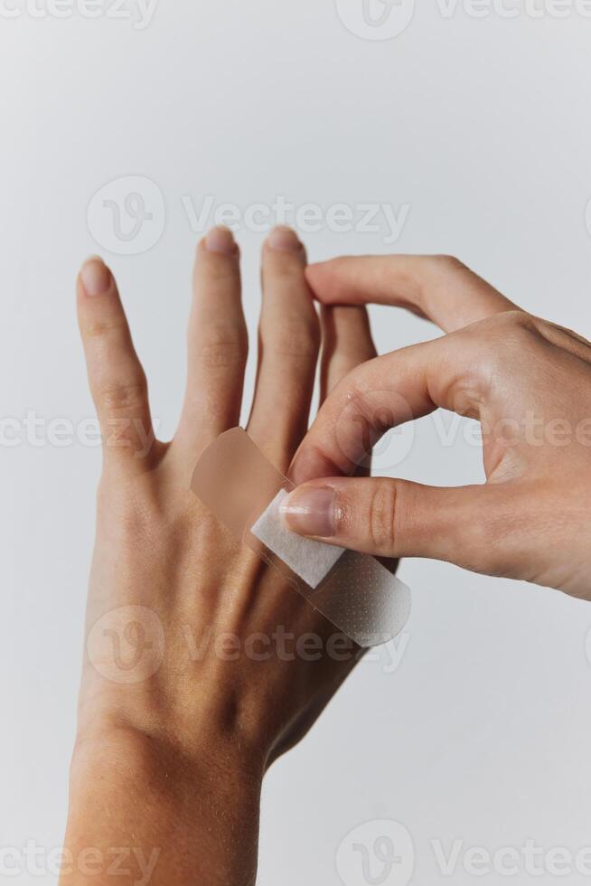 Bandaged hands of two people, one with visible scars. photo