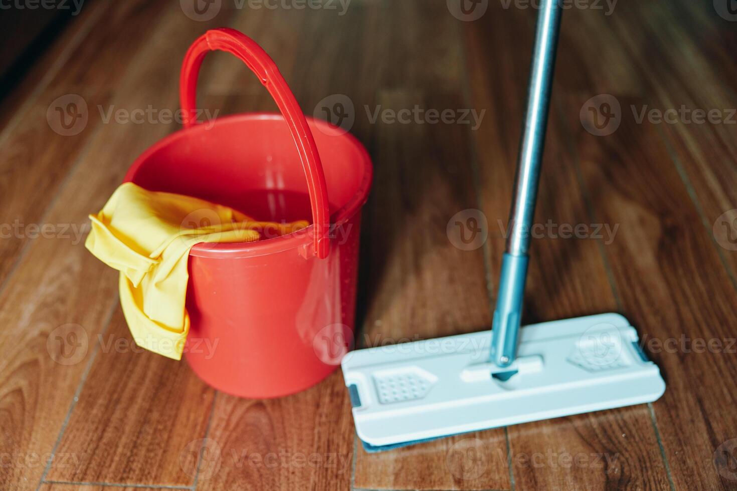 Bucket, mop, water and yellow cloth on wooden floor. cleaning supplies for household chores. a photo