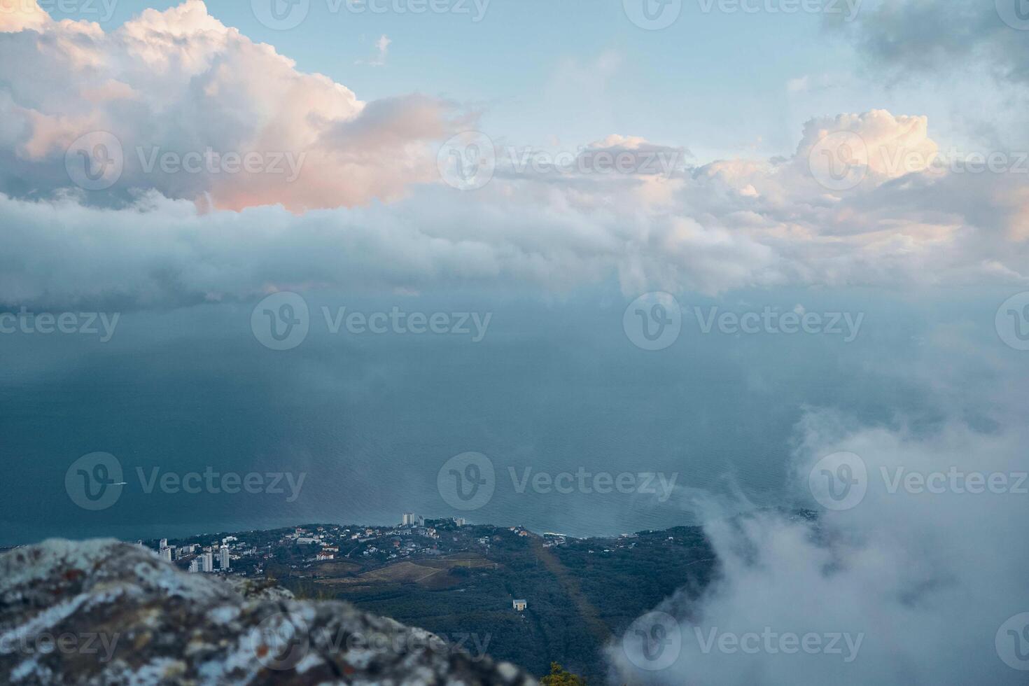 Serene Ocean View from a Majestic Mountain Summit with Fluffy Clouds in the Sky photo