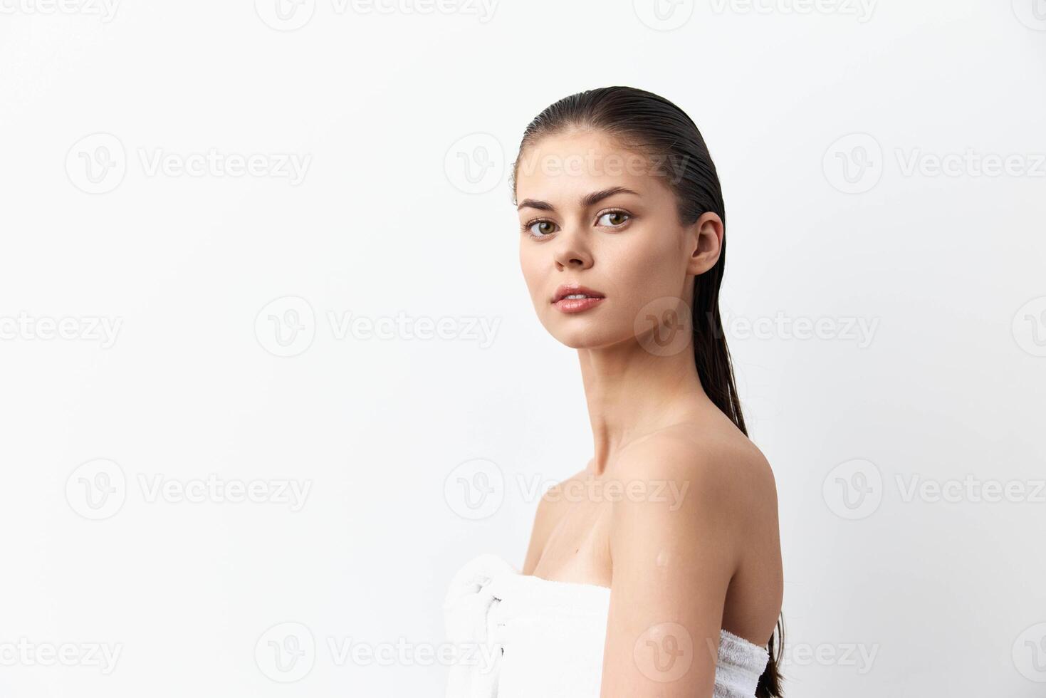 Captivating image of a young woman with sleek wet hair, standing confidently against a clean white photo