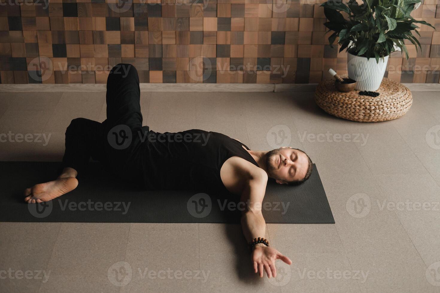 A man performing gymnastic exercises on a yoga mat at home photo