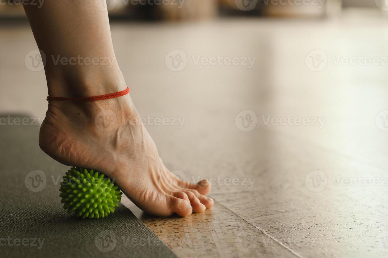 Close - up of the legs of a woman performing gymnastic exercises to correct flat feet during ball massage at home photo