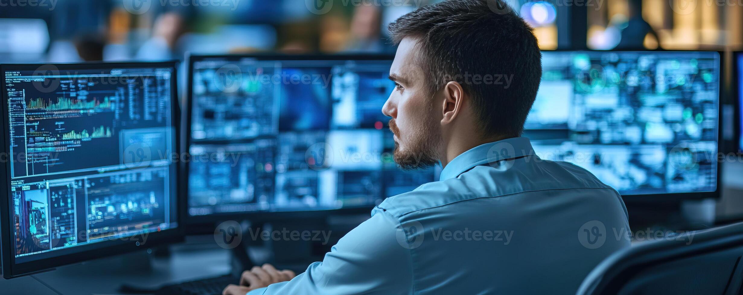 Focused man analyzing data on multiple screens in a modern office environment. photo