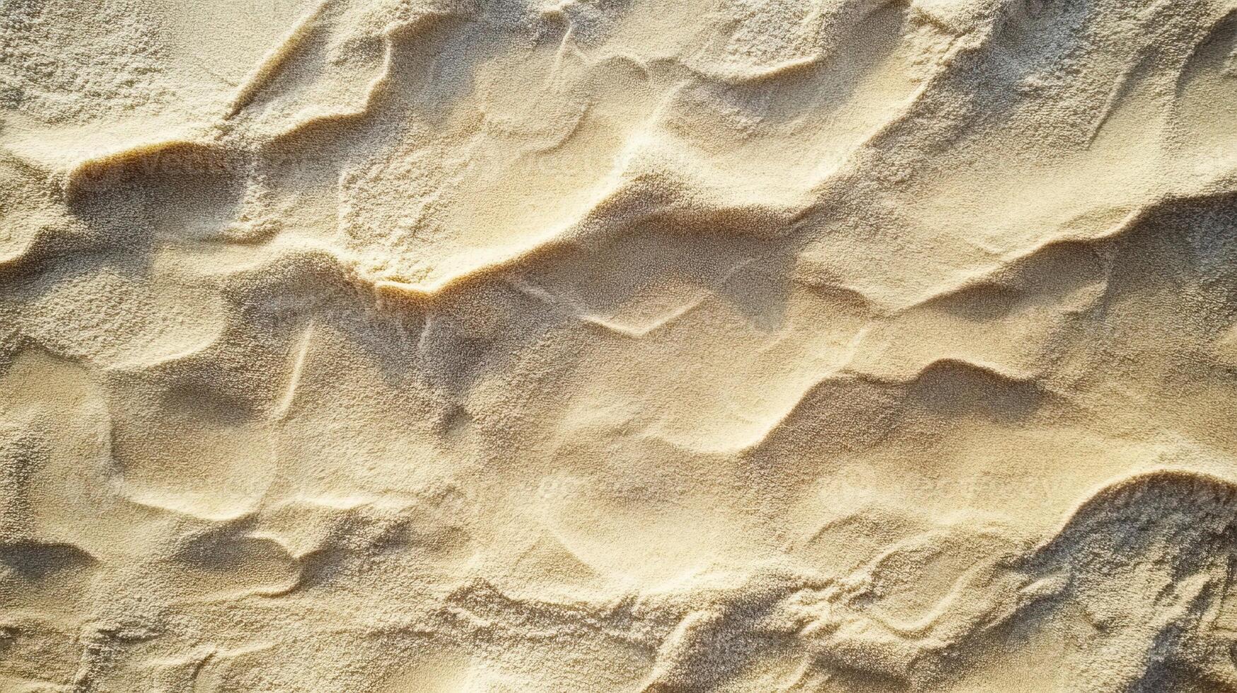 Textured sandy surface under sunlight, ideal for backgrounds or design elements. photo