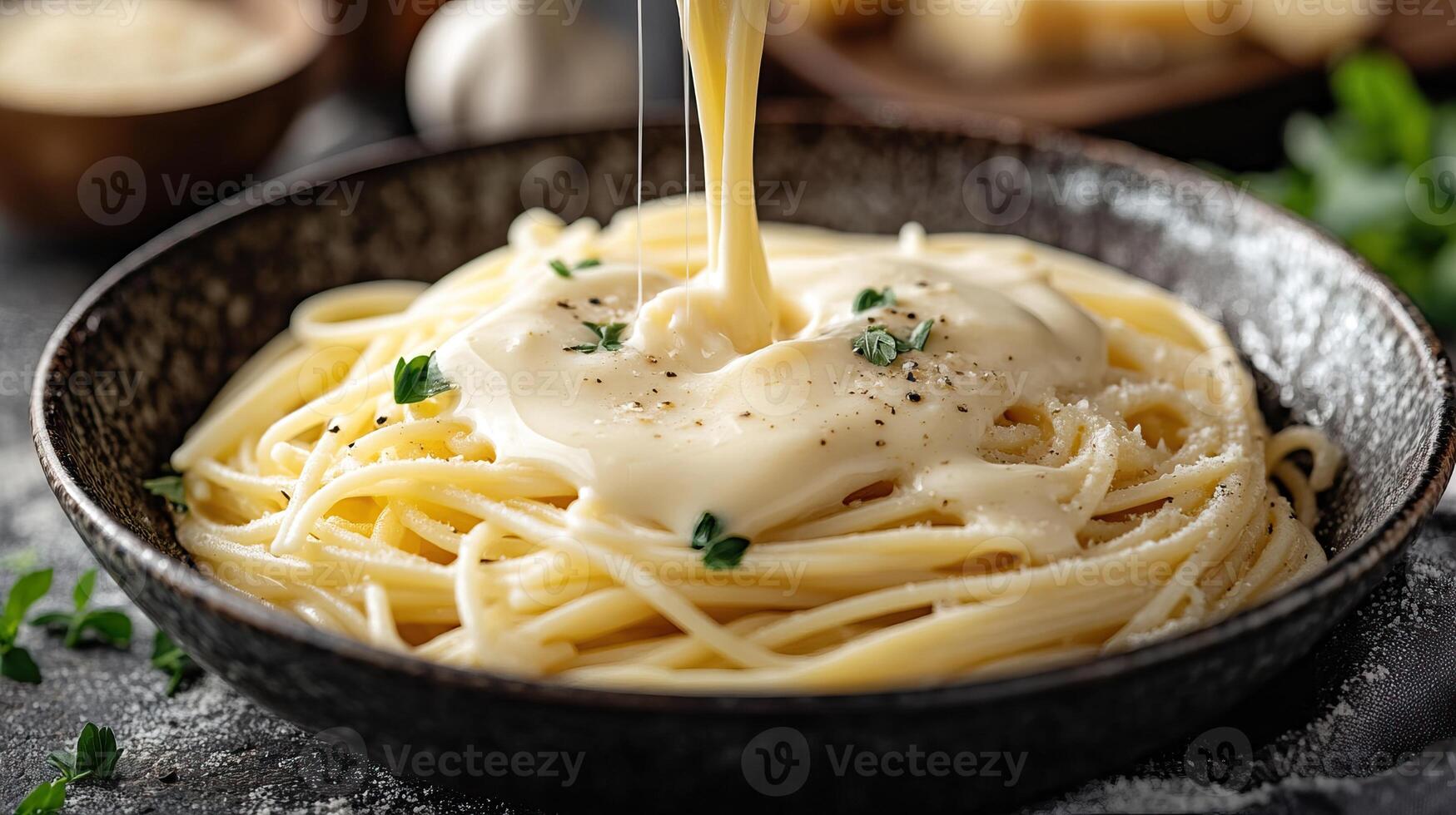 Delicious creamy pasta served in a black bowl, garnished with herbs and cheese, ready to indulge. photo