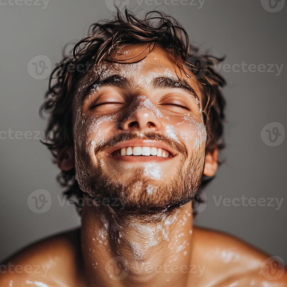A young man smiling with a clean face, enjoying a refreshing skincare routine. photo