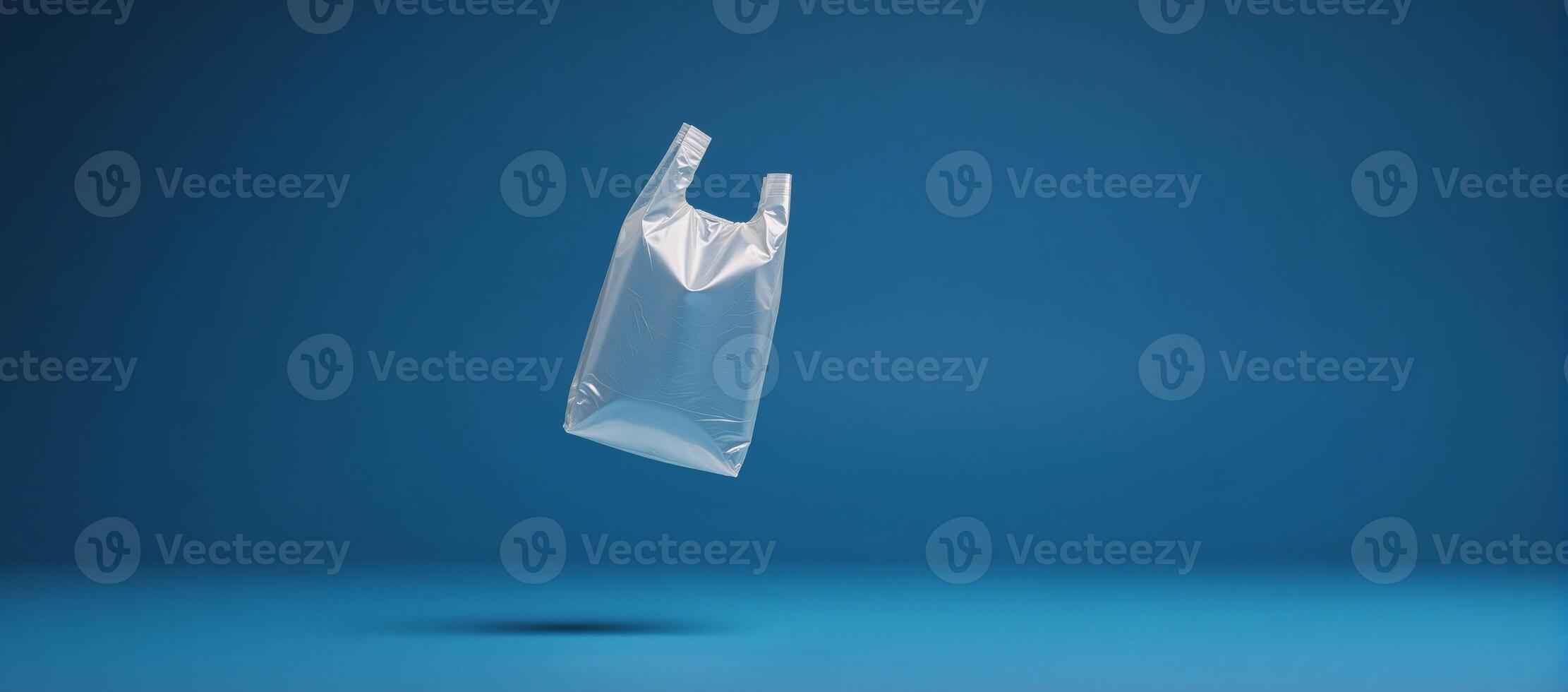 Plastic bag floating against blue backdrop photo