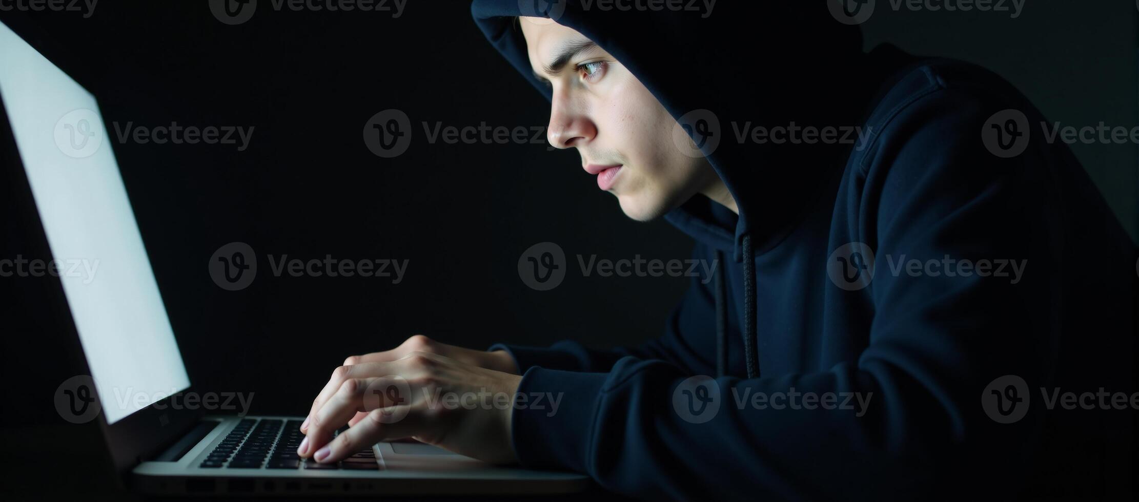 A hacker engages in cybercrime through his laptop on a dark backdrop while a young hacking prodigy battles him in an Internet Security Standoff photo