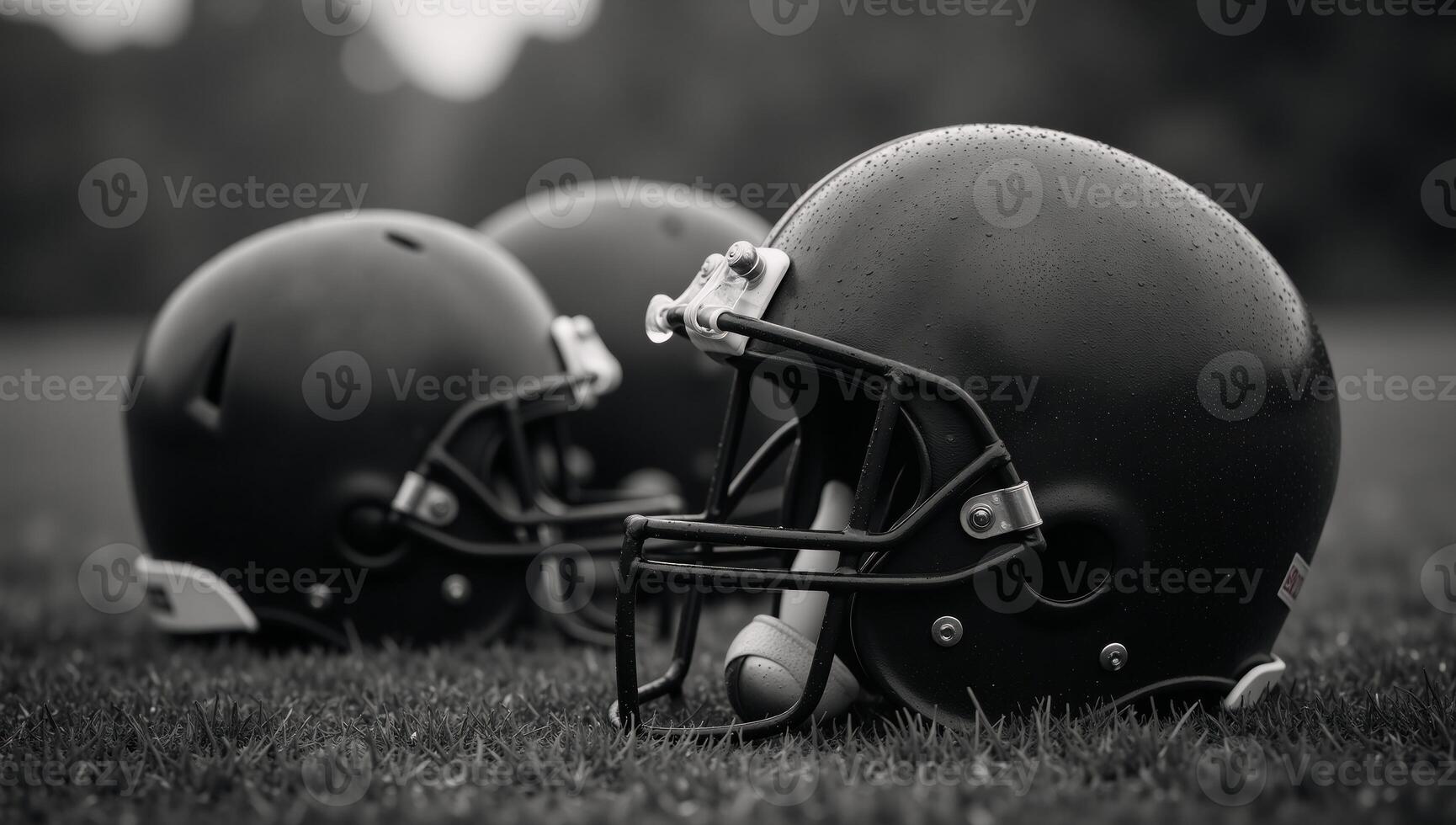 Worn football helmets on rainsoaked field with bokeh light effects photo