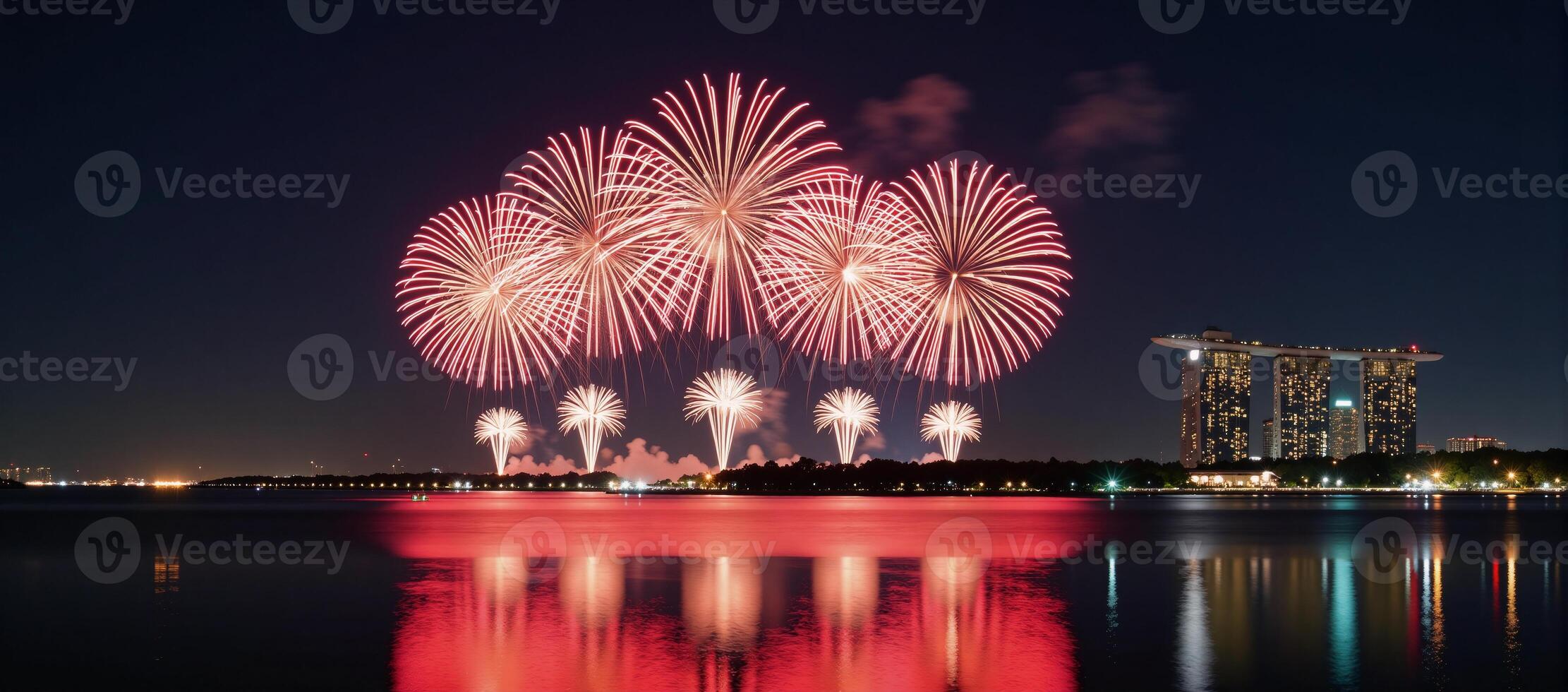 Fireworks display illuminating city skyline at night over water reflection photo